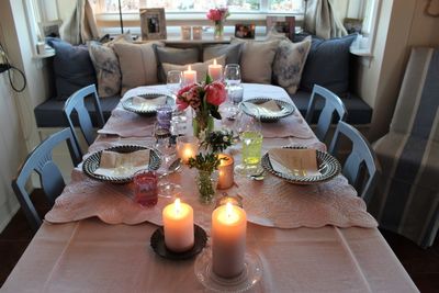 High angle view of lit candles on dining table at home