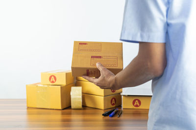 Midsection of man holding toy blocks against white background