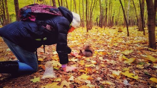 Rear view of woman standing in forest