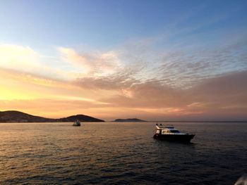 Boat sailing in sea at sunset