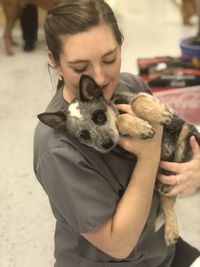 Young woman holding dog outdoors