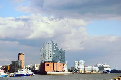 Modern buildings by sea against sky