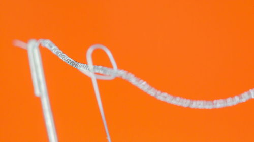 Close-up of rope against orange background