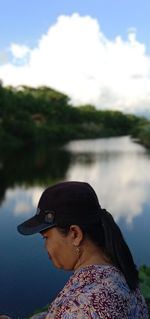 Side view of man looking at lake against sky