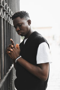 Young african man outdoor, street portrait. hands holding gun pose