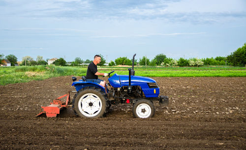 A farmer on a tractor cultivates a field. farm work. milling soil, softening the soil