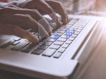 Cropped hands using laptop on table