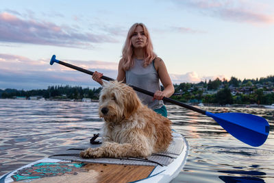 Woman with dog on boat against sky