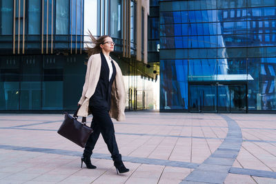 Successful happy business woman with bag over office building background person