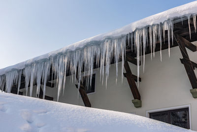 Panoramic shot of icicles on roof against clear sky