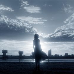 Silhouette people standing against cloudy sky