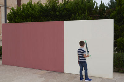 Rear view of man standing against wall