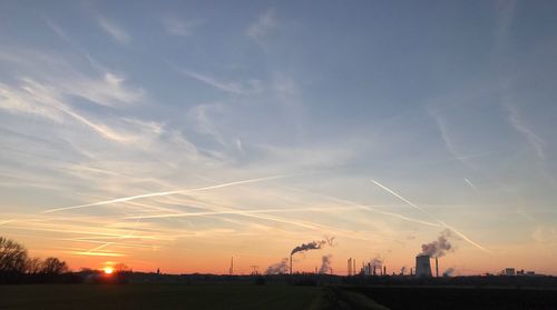 Silhouette of electricity pylon against sky during sunset