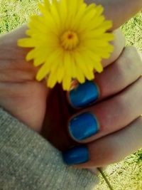 Low section of woman with yellow flower