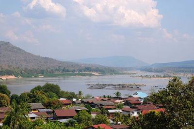 High angle view of townscape by lake against sky