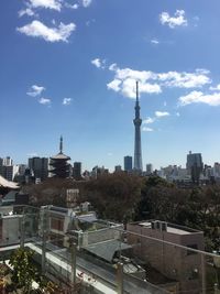 Buildings in city against cloudy sky