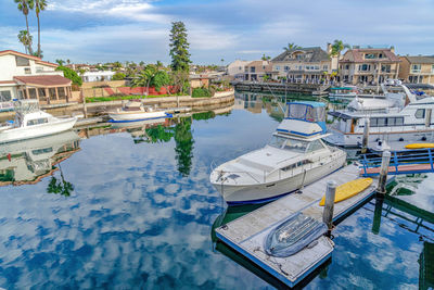 Boats moored at harbor against buildings in city