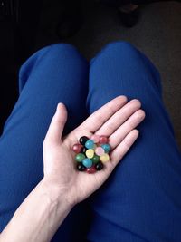 Midsection of woman holding colorful marbles