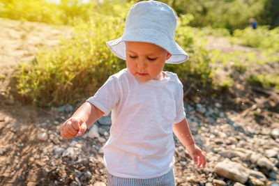 Boy looking away while standing on land