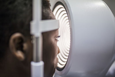 Black woman in optometry cabinet during study of the eyesight using a modern corneal topographer