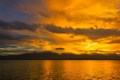 Scenic view of sea against dramatic sky during sunset