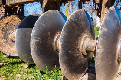 Close-up of old rusty wheel on field