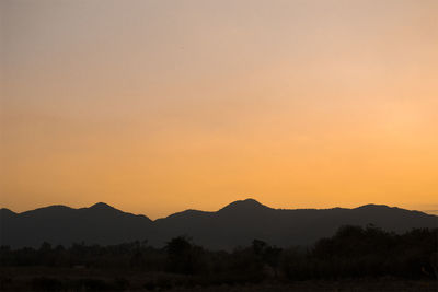 Scenic view of silhouette mountains against sky at sunset