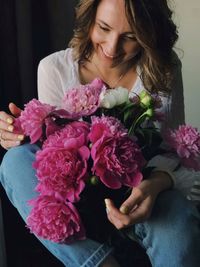Midsection of woman holding pink flower bouquet