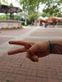 Close-up of hands against sky