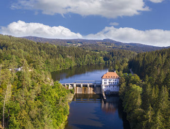 Drone view of hydroelectric power station on hollensteinsee lake and surrounding forest in summer