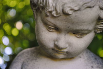 Close-up of boy statue against trees