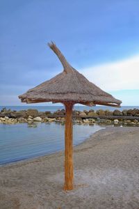 Wooden posts on beach against sky