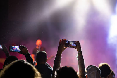 Group of people photographing at music concert