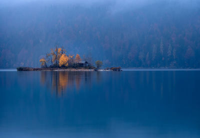 Scenic view of lake by trees against sky