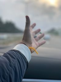 Cropped hand of person by window in car