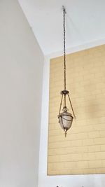 Low angle view of pendant light hanging on wall