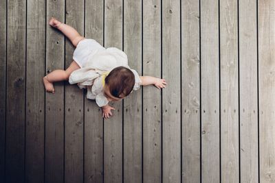 High angle view of woman lying on wooden floor