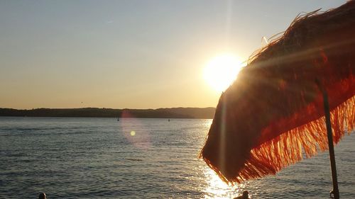 Sun shining over calm sea at sunset