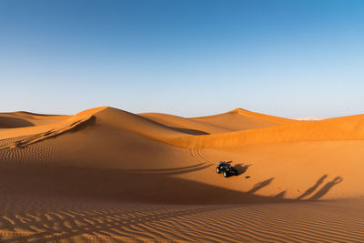 Scenic view of desert against clear blue sky