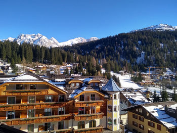 Houses on snowcapped mountain against clear sky