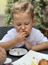 Close-up of boy eating food at home