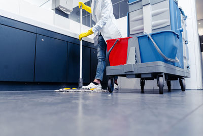 Low section of man cleaning floor in public restroom