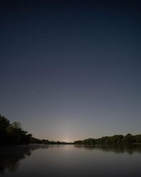 Scenic view of lake against sky at night