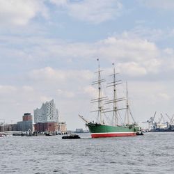 Sailboats sailing in sea against sky