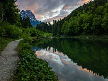 Scenic view of lake by trees against sky