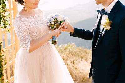 Midsection of couple standing against sky