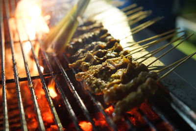 Close-up of meat satay on barbecue grill at market