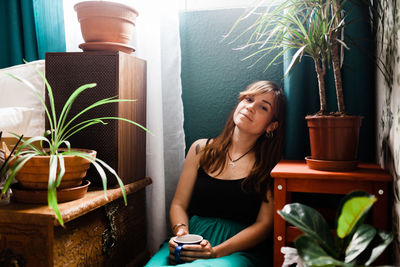 Young woman sitting on table at home