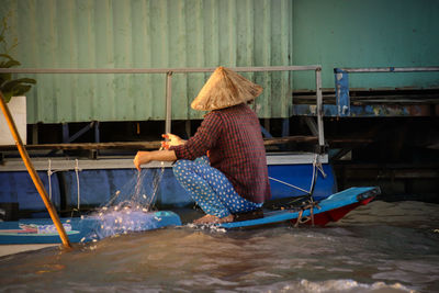 Rear view of woman working in water