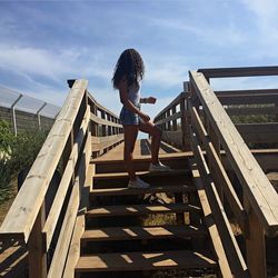 Full length of boy on staircase against sky